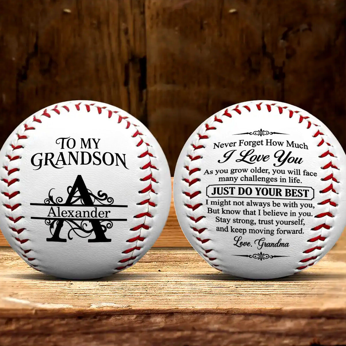 Two personalized baseballs for a grandson named Alexander on a wooden table: the front shows To My Grandson above a monogram of the letter A, the back shows the printed message signed Love, Grandma