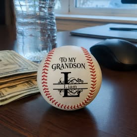 Customer photo of a personalized baseball for his grandson Liam, standing on a desk by a window